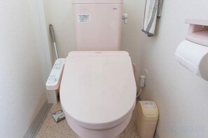 A small bathroom with a toilet, a bidet, and a trash bin. - QingChen zhi Shu (Osaka)