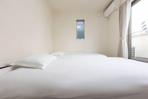 A hotel room with a bed, a window, and an air conditioning unit. - QingChen zhi Shu (Osaka)