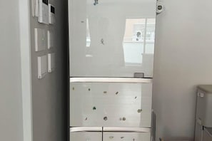 A kitchen with a refrigerator, a microwave, and a sink. - QingChen zhi Shu (Osaka)