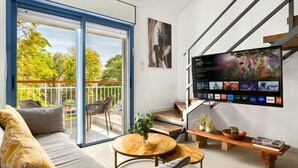 Un salon moderne avec un canapé, une table basse et un téléviseur fixé au mur.
