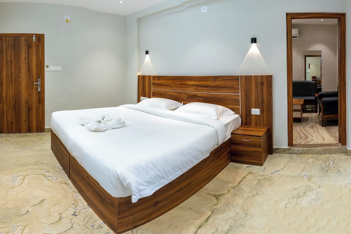 Een slaapkamer met een houten bed, nachtkastjes en een spiegel.