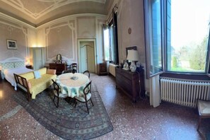 Una habitación con una cama, un sofá, una mesa y una ventana.