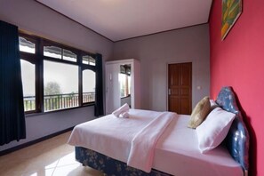 A bedroom with a bed, a wardrobe, a door, and a window with a view. - Mountain View House Kintamani (Bali)