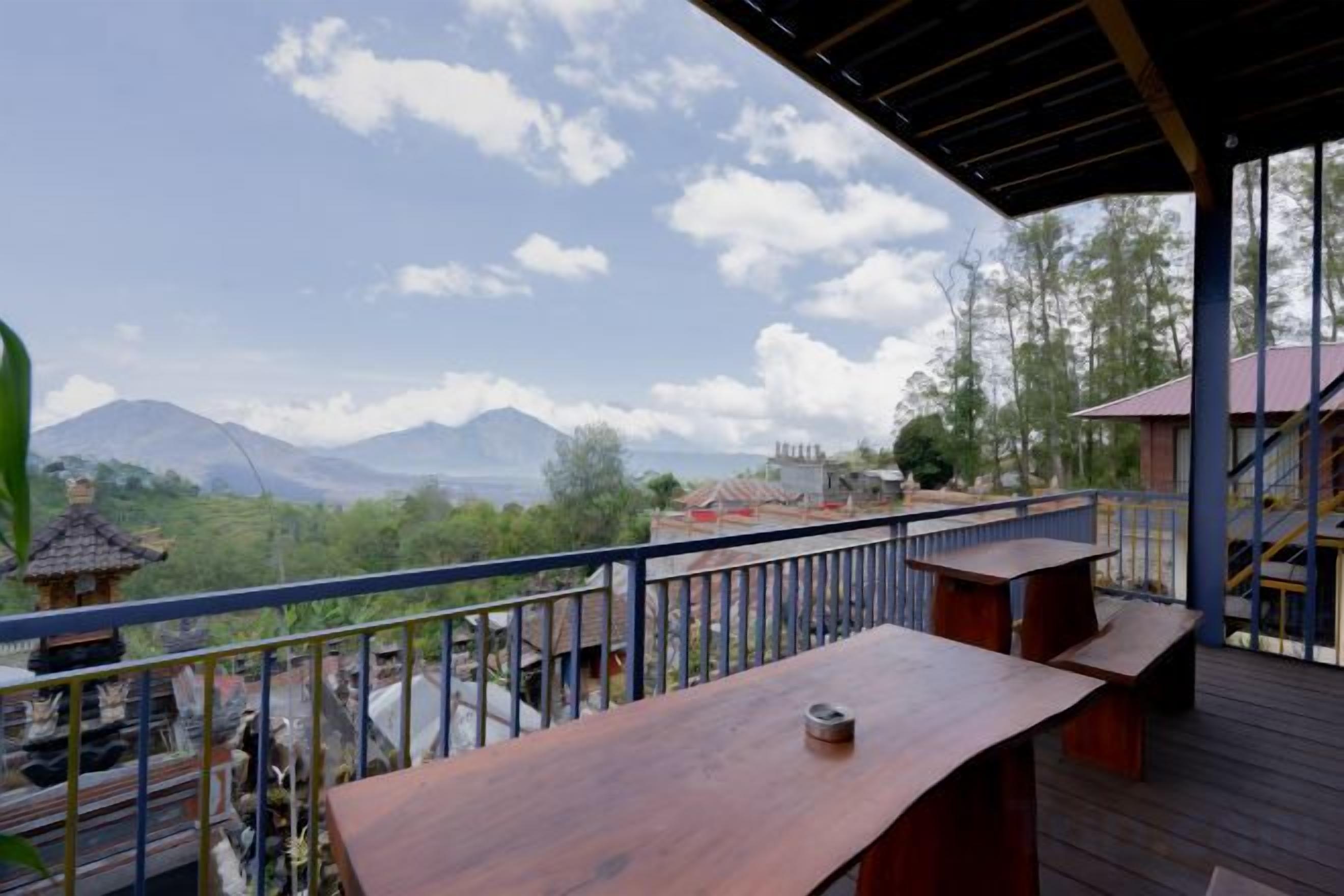 A wooden deck with a railing overlooking a mountainous landscape.