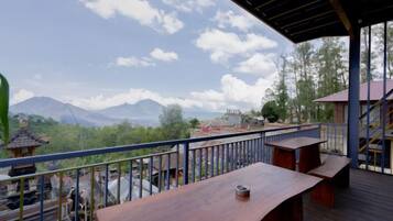 A wooden deck with a railing overlooking a mountainous landscape.