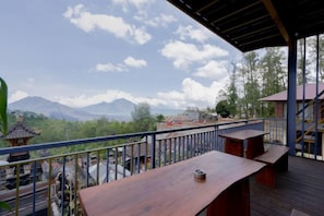 A wooden deck with a railing overlooking a mountainous landscape. - Mountain View House Kintamani (Bali)