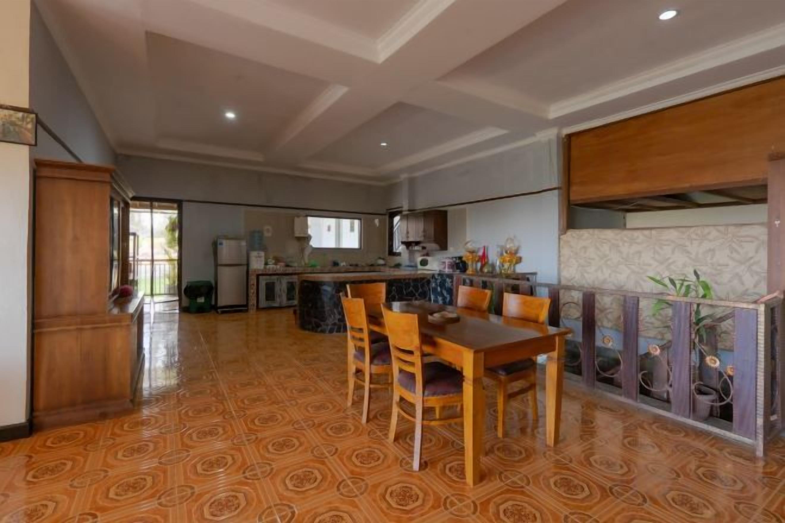 Una cocina amplia con comedor, que presenta un piso estampado, muebles de madera y vistas al exterior.
