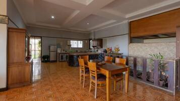 Una cocina amplia con comedor, que presenta un piso estampado, muebles de madera y vistas al exterior.