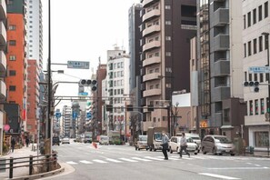 A city street with buildings, vehicles, and a pedestrian crossing. - YOOSUU Nippori self-help Apartment (Tokyo)