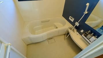 A small bathroom with a bathtub, a shower, and a toilet.