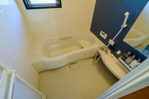 Pieni kylpyhuone, jossa on kylpyamme, suihku ja wc.