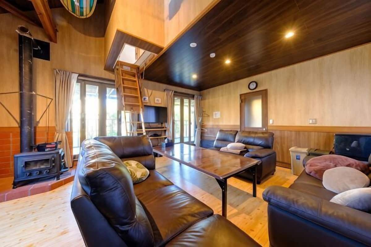 A cozy living room with leather sofas, a wooden table, and a fireplace.