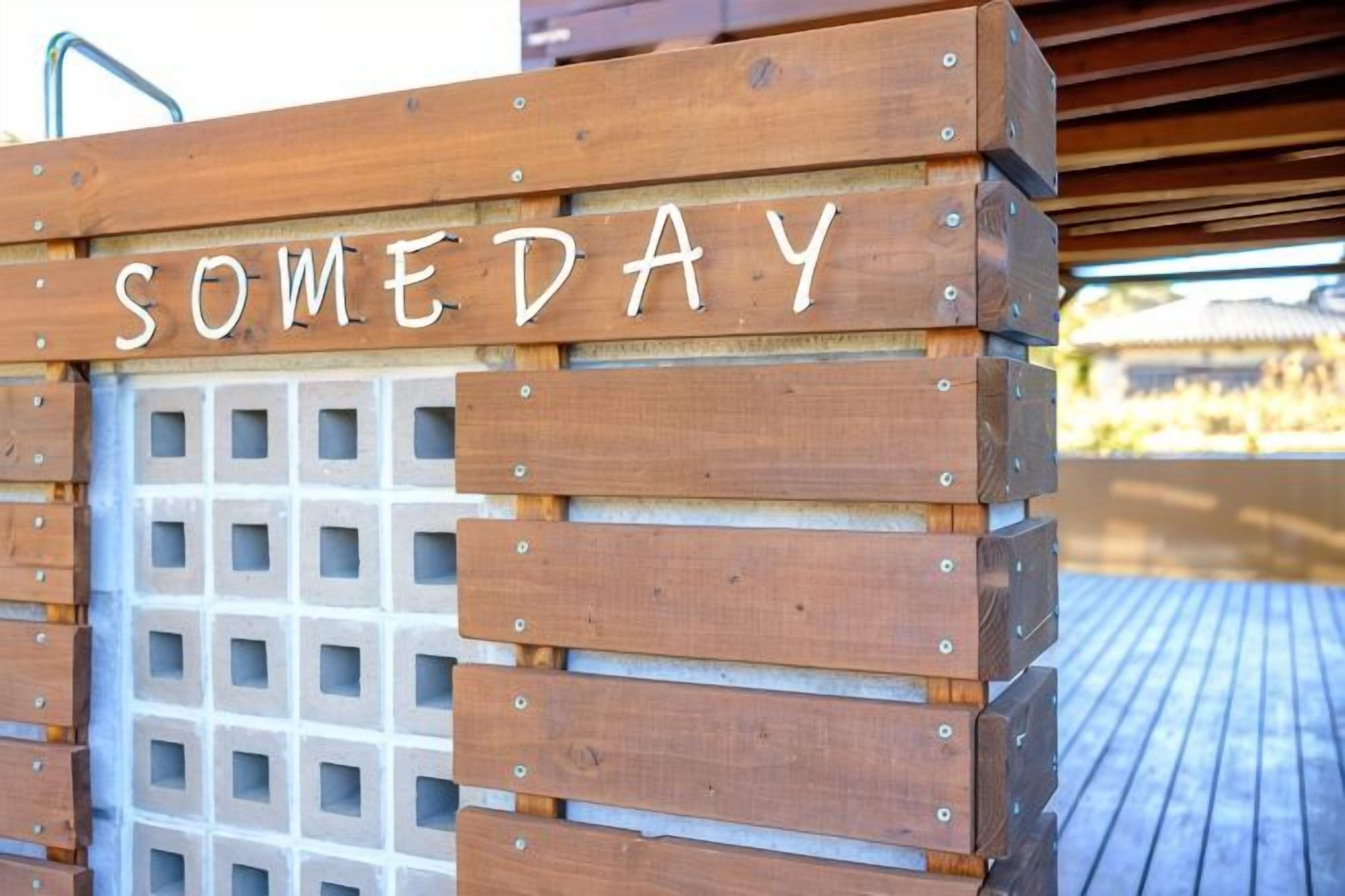 A wooden bench with the word 'SOMEDAY' spelled out in white letters.