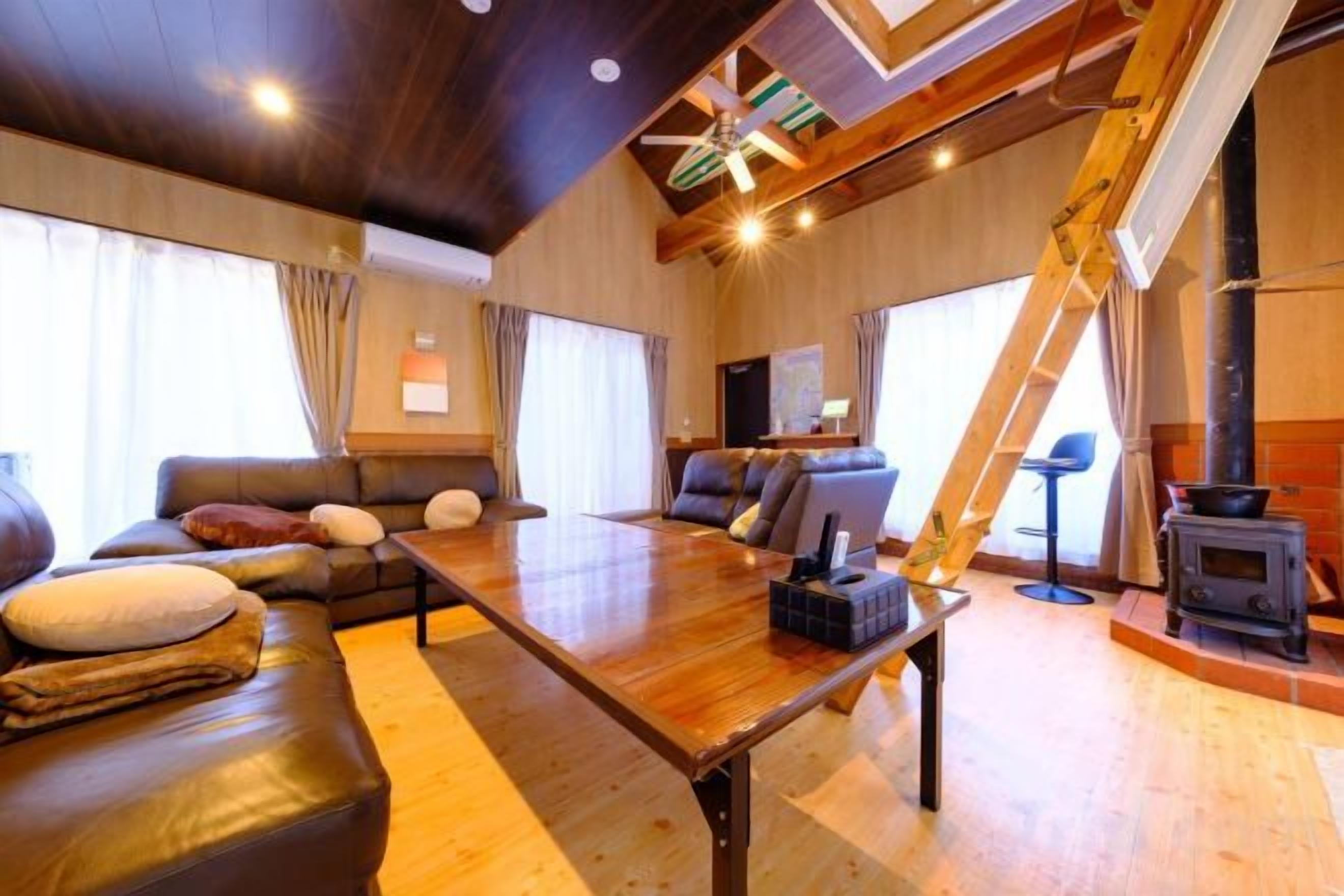 Ein gemütliches Wohnzimmer mit einem Holztisch, einer Ledersofa und einem Kamin.