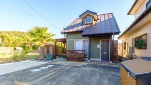 Une maison avec un toit en métal, un porche à l’avant et un garage.
