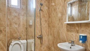 Ein Badezimmer mit Toilette, Dusche, Waschbecken und einem Spiegel.