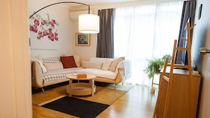 A living room with a sofa, a coffee table, a lamp, and a wooden ladder. - Darling Street Residence - Self Check-In Only (South Yarra)