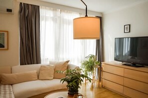 A living room with a sofa, a television, a lamp, and a plant. - Darling Street Residence - Self Check-In Only (South Yarra)
