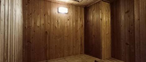 Una sauna con pareti e panche in legno.