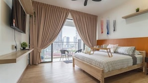 Une chambre à coucher avec un lit, une télévision, un balcon et des rideaux.
