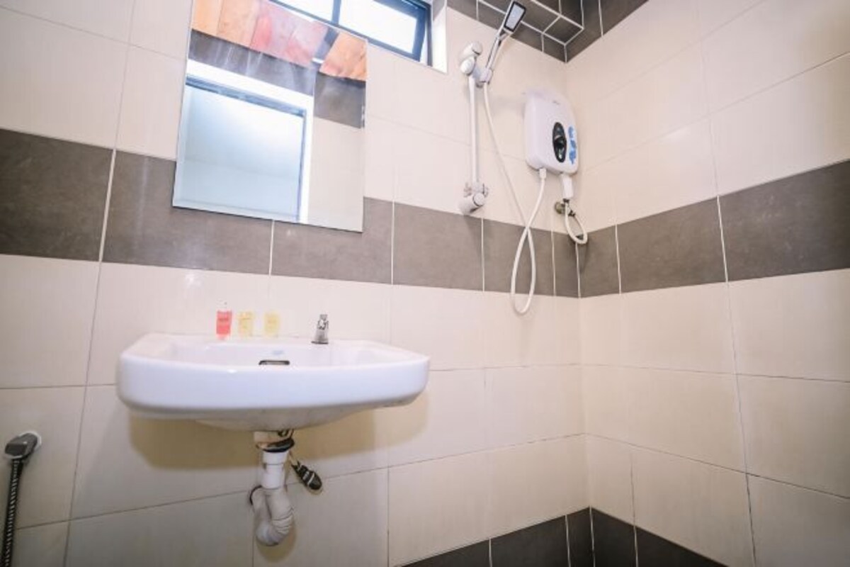 Un baño con lavamanos blanco, un espejo y una ducha.