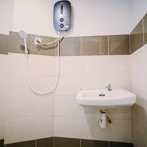 Un baño con un lavamanos blanco, un cabezal de ducha de mano y un dispensador de jabón de pared.