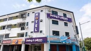 Een hotel met een bordje voor 'Swing & Pillows' en 'BubbleLab' op de begane grond.