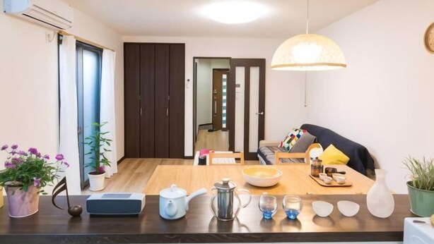 A modern kitchen with a wooden countertop, a kettle, a coffee pot, and a dining table with chairs. - New cozy House near Kamogawa River　 STAR (Kyoto)