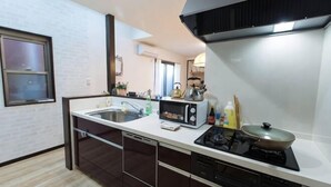 A modern kitchen with a dishwasher, microwave, stove, and sink. - New cozy House near Kamogawa River　 STAR (Kyoto)