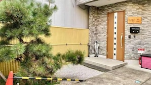 A hotel entrance with a stone facade, a wooden door, and a small outdoor seating area. - New cozy House near Kamogawa River　 STAR (Kyoto)