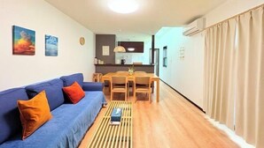 A compact living space with a sofa, a dining table, and a kitchen area. - New cozy House near Kamogawa River　 STAR (Kyoto)