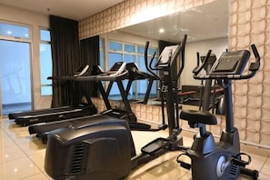 A gym with treadmills, elliptical machines, and a mirrored wall. - Mount Austin Muji Style 4 pax Deluxe Room (Tebrau)