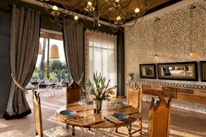 A dining area with a round table, chairs, and a chandelier. - The Source Hotel Music & Spa (Marrakech)