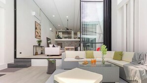 A modern living room with a sofa, coffee table, and a view of a kitchen and dining area.