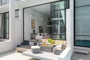 Un salon moderne avec un canapé, une table basse et une grande fenêtre.