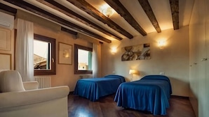A room with two beds, a sofa, wooden beams on the ceiling, and a window with curtains. - Rooftop Terrace Penthouse & 360° Views Venice5th (Venice)