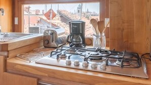 A kitchen with a gas stove, toaster, coffee maker, and utensils. - Rooftop Terrace Penthouse & 360° Views Venice5th (Venice)