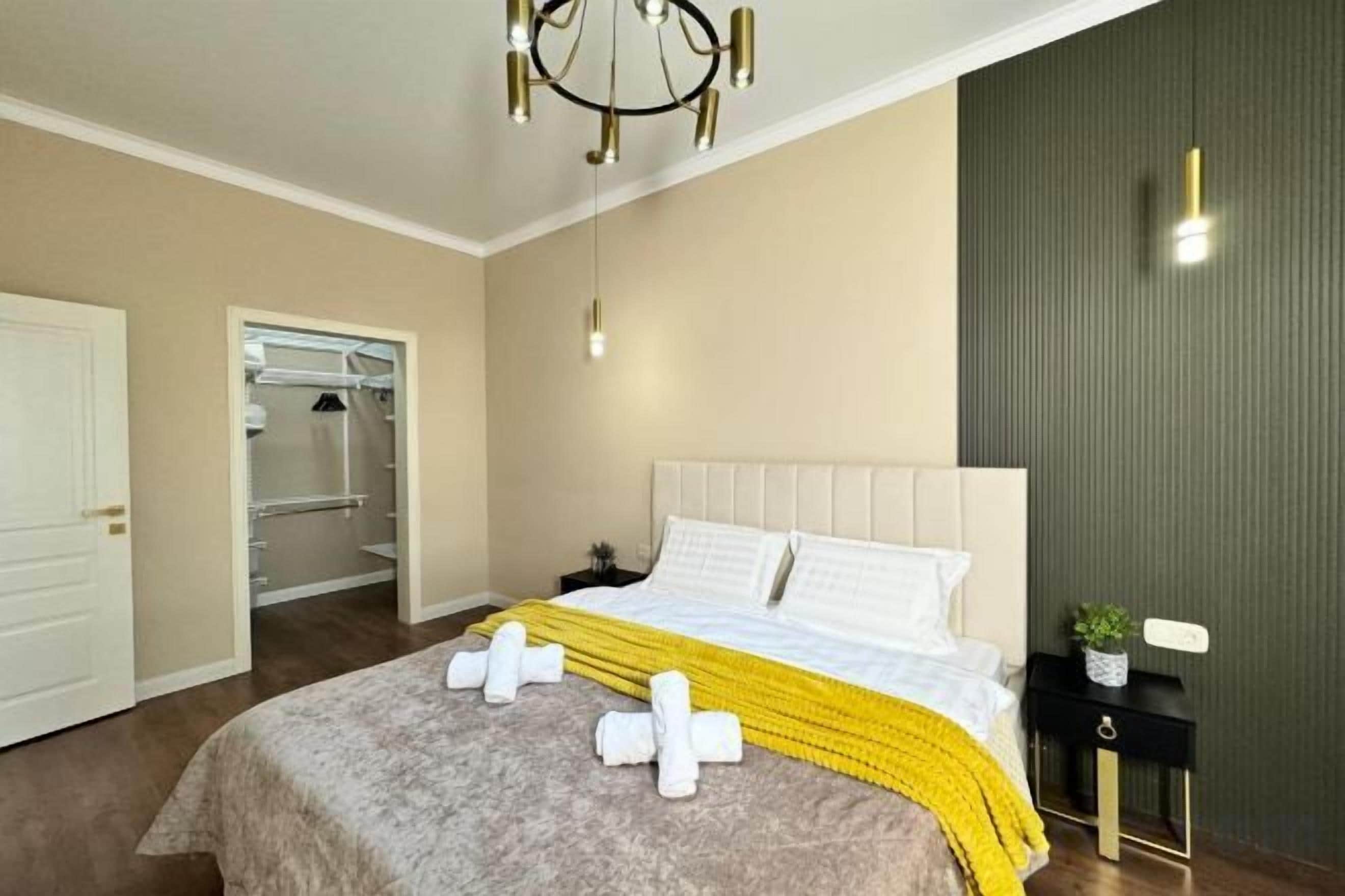A hotel room with a bed, bedside table, and a closet.