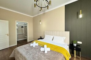 A hotel room with a bed, bedside table, and a closet. - Comfort City (Almaty)