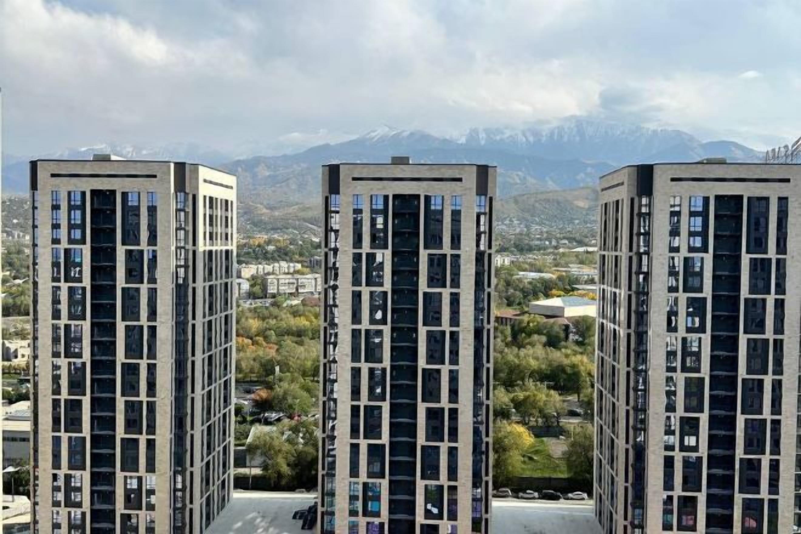 Three high-rise buildings with a mountainous backdrop.