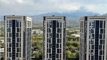 Three high-rise buildings with a mountainous backdrop.