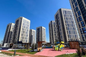 A residential area with high-rise buildings, a playground, and a small pavilion. - Comfort City (Almaty)