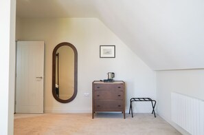 Une chambre à coucher avec une commode, un miroir, un radiateur et un tableau encadré au mur.