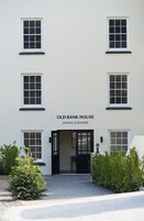 Un edificio con un letrero que dice 'OLD BANK HOUSE DINING & ROOMS' en la entrada.