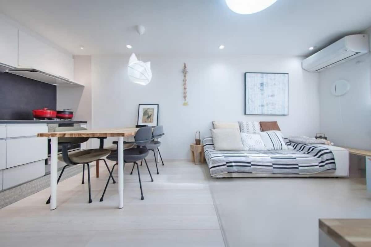 A modern, compact living space with a kitchenette, a dining area, and a bed.