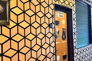 A door with a geometric pattern and a sign indicating a washroom and a coffee machine. - Palz Empire Hotel (Temerloh)