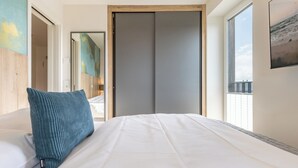 Una camera da letto con un letto, un cuscino color petrolio, una porta scorrevole e una finestra vista.