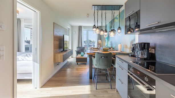 Una cucina moderna con zona pranzo, ampie finestre e vista sulla città.