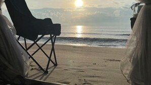 A beach view with a chair and a bag, suggesting a beachside setting. - Earnhomestay sichon (Sichon)