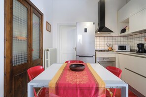 Uma cozinha compacta com geladeira branca, micro-ondas e fogão.